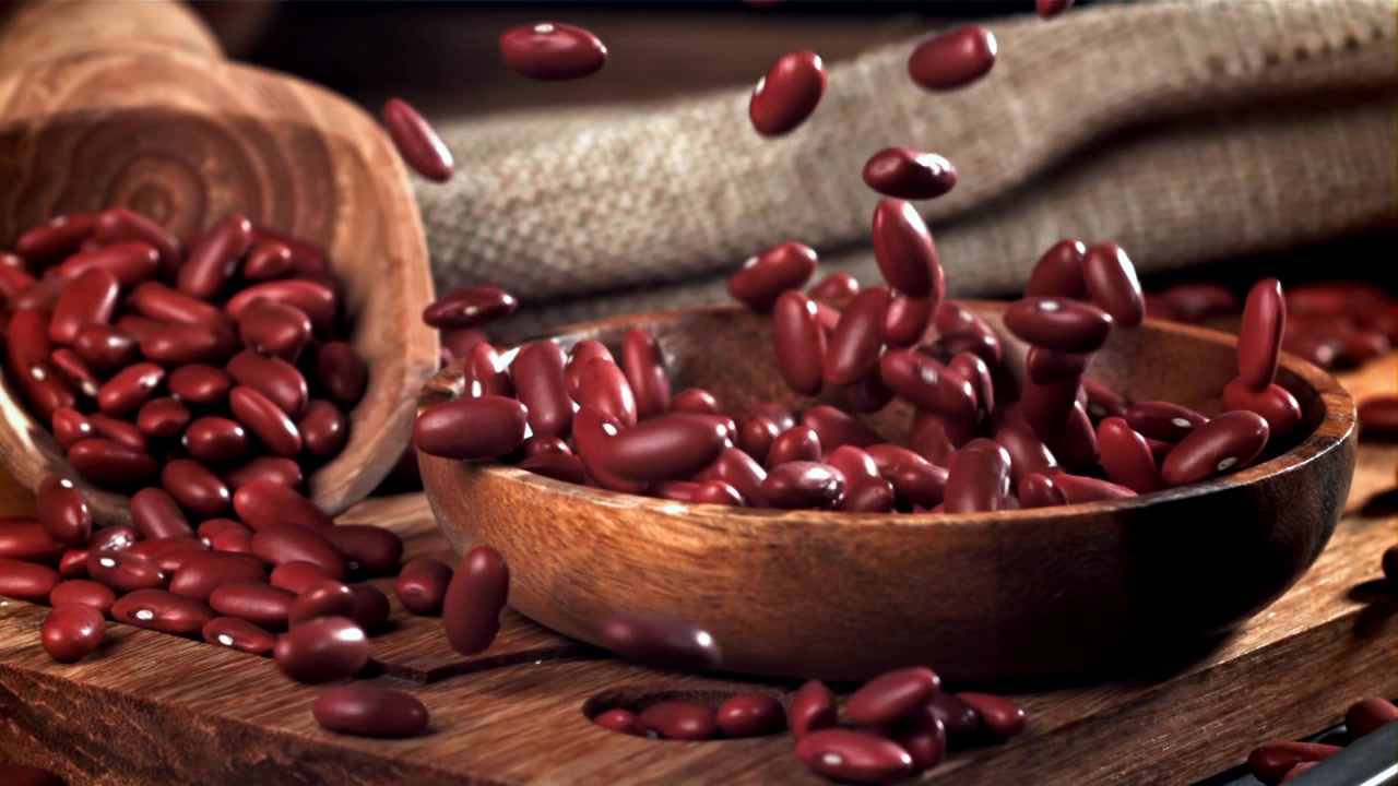 Red Kidney Beans Falling into a Wooden Bowl in Slow Motion