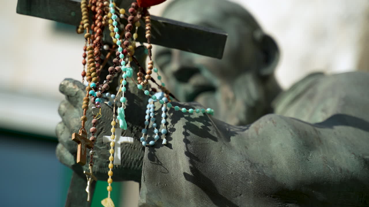 estatua de san pío con rosarios drapeados sobre la cruz cristiana que sostiene en atrani en la costa italiana de amalfi