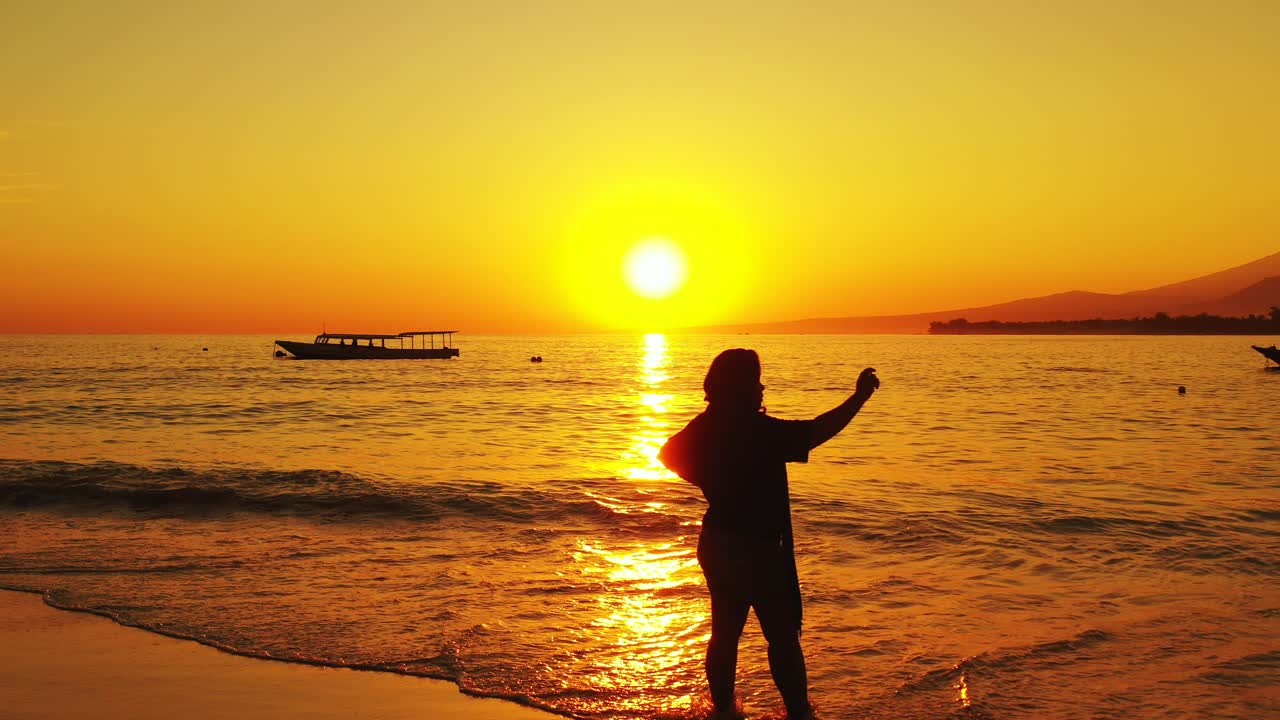 셀카를 찍거나 모래사장에서 블로그를 하는 소녀, 필리핀 일몰