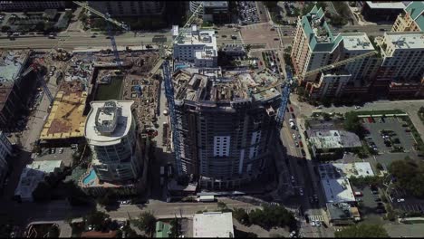 a high rise construction project with two tower cranes in a downtown area