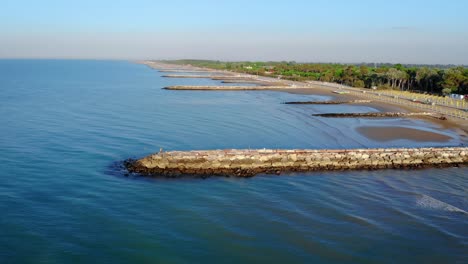 Aerial-drone-view-moving-toward-pier-over-stunning-blue-water