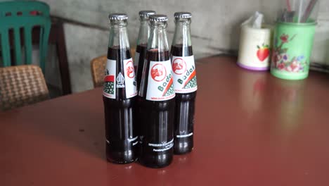 Slow motion shot of traditional Indonesian Badak glass bottles in a restaurant