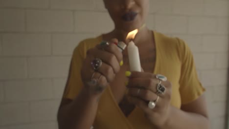 An-alternative-girl-in-a-yellow-dress-provokes-by-lighting-a-candle-and-dripping-wax-on-her-tongue-with-a-piercing