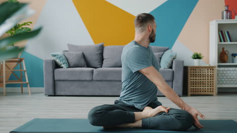 man practicing yoga at home