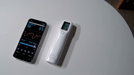 smartphone and digital thermometer on a table