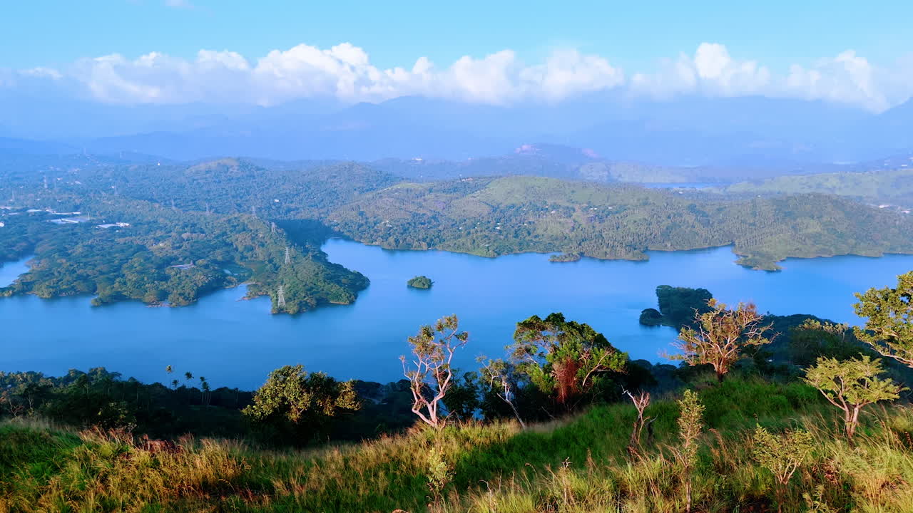 Coming closer to the edge of the mountain. Revealing view on the beautiful azure waterscape among the hills. Sri Lanka, South Asia.