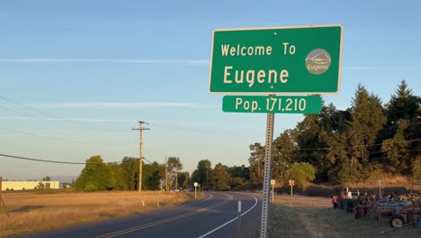 señalización en la carretera de eugene, oregón, dando la bienvenida y enumerando la población