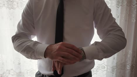 groom's preparing his watch at home