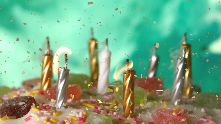 Animazione di coriandoli che cadono su candele su una torta di compleanno
