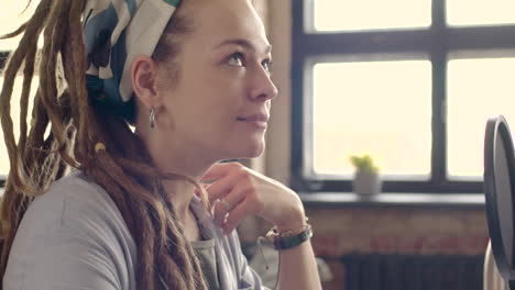 vista lateral de una mujer con auriculares hablando por un micrófono mientras graba un podcast