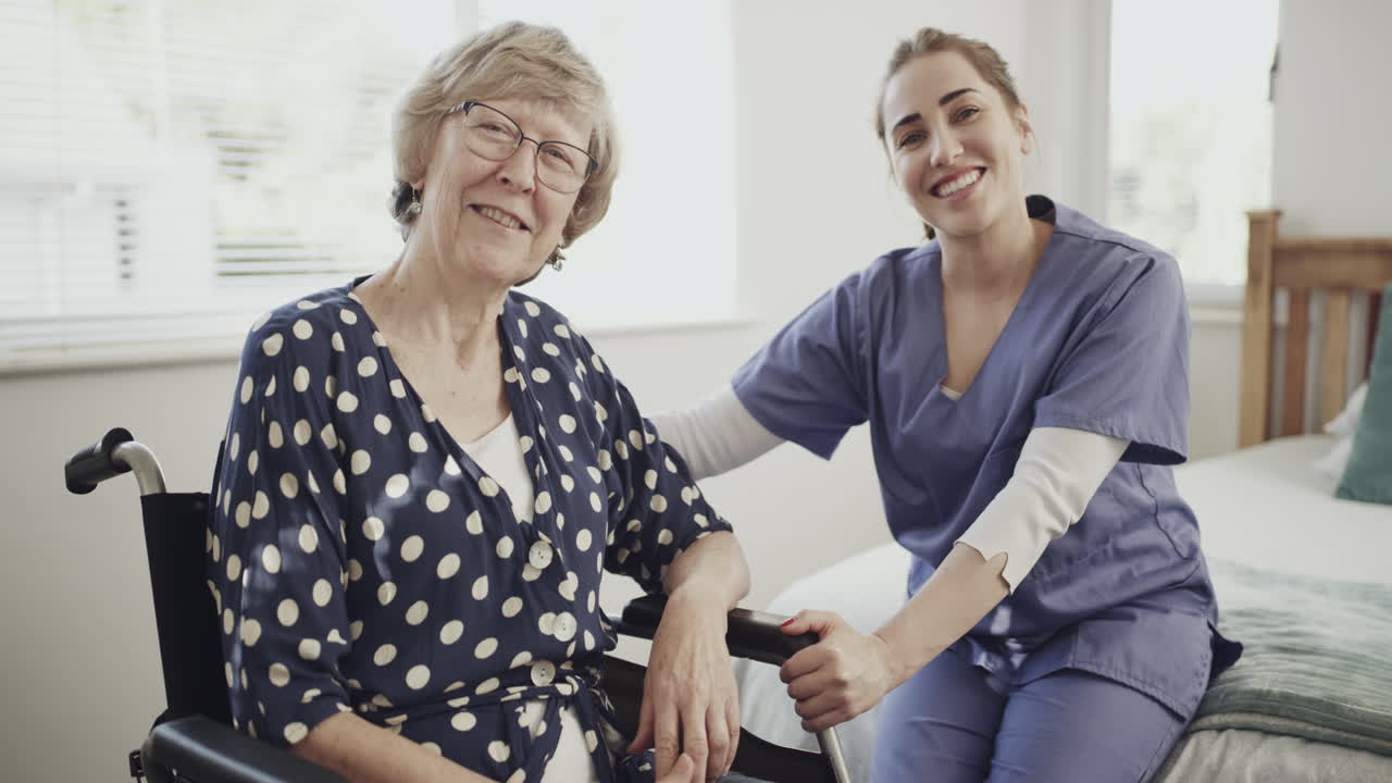 Pflegekraft unterstützt Seniorin im Rollstuhl