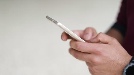 close up shot of mixed-race male hands texting on phone