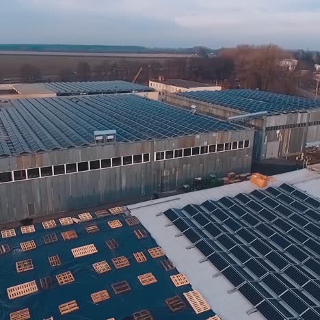 solar panels on roofs of industrial buildings in the evening. sunny batteries for getting new alternative energy from the sun. aerial view.