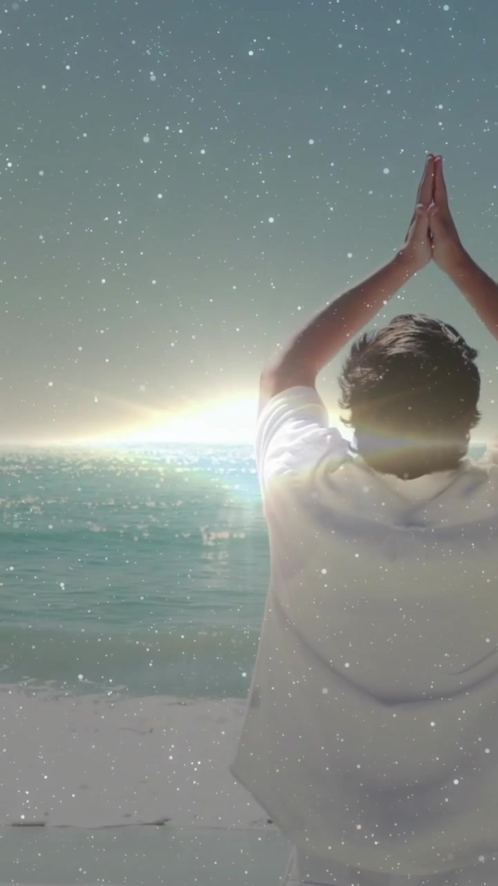 Video vertical: Hombre meditando contemplando el horizonte, abriendo los brazos, uniendo las palmas, bajando, con superposición de estrellas.