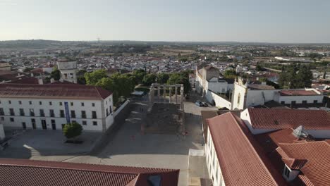 ruinas del templo romano en el centro histórico de evora con paisaje urbano en el fondo, portugal