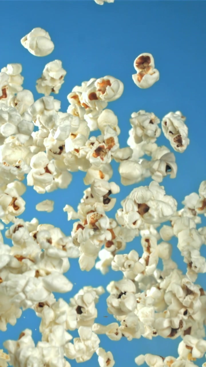 Popcorn che cadono e fluttuano su uno sfondo blu