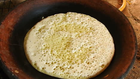 food shot of some homemade traditional moroccan baghrer in clay fryer , pancakes baghrir or crapes with 1000 holes