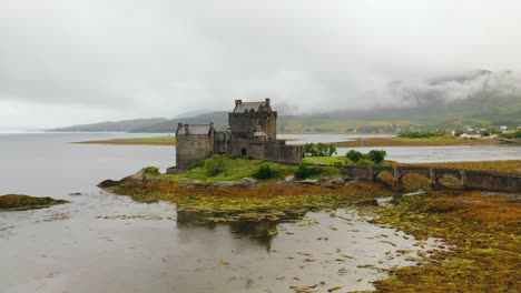 Impresionante-Toma-Aérea-Del-Castillo-De-Eilean-Donan-En-Las-Tierras-Altas-De-Escocia,-Punto-De-Referencia-Escocés-En-El-Lago,-Escocia