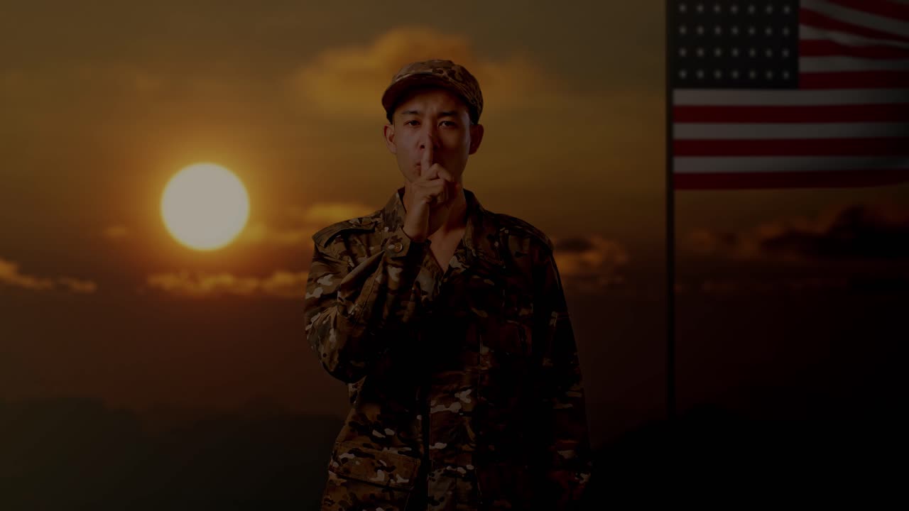 soldado en uniforme de camuflaje con el dedo en los labios al atardecer