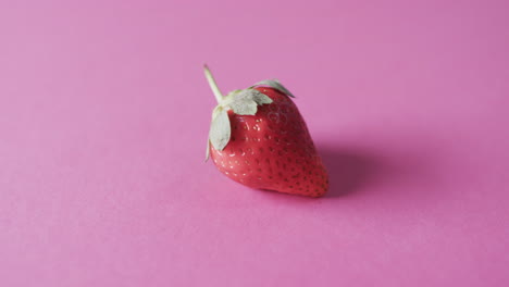 video of strawberry with copy space over pink background