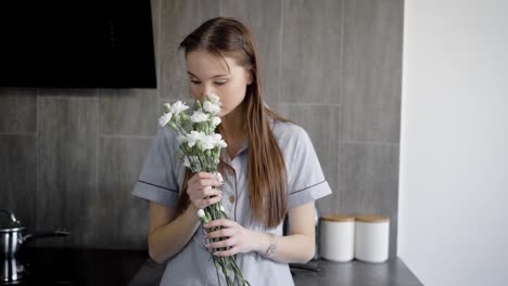 portrait of lovely brunette woman holding flowers indoor