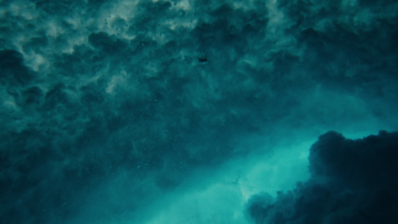 Underwater turbulence and foam from powerful breaking ocean wave textured spray and natural foam bubbles, slow motion abstract explosion