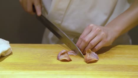 chef cutting fresh meat for sushi in a chinese restaurant in guangzhou, china - close up