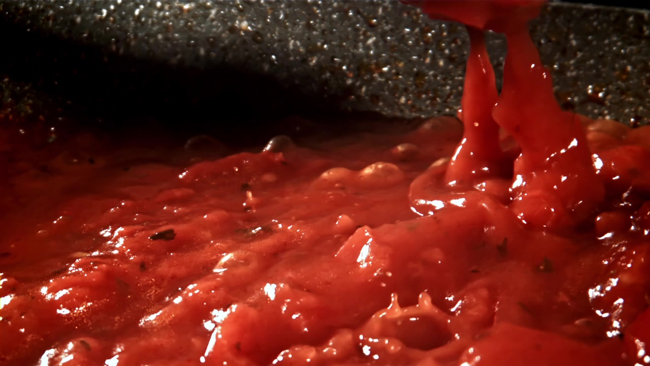 Primo piano di salsa di pomodoro rossa che sobbolle e gorgoglia in una pentola