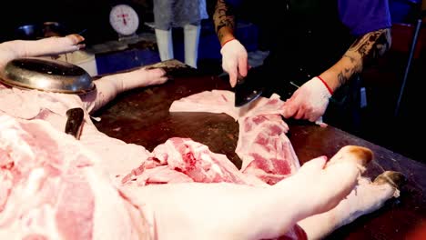 butcher slices large piece of meat on table