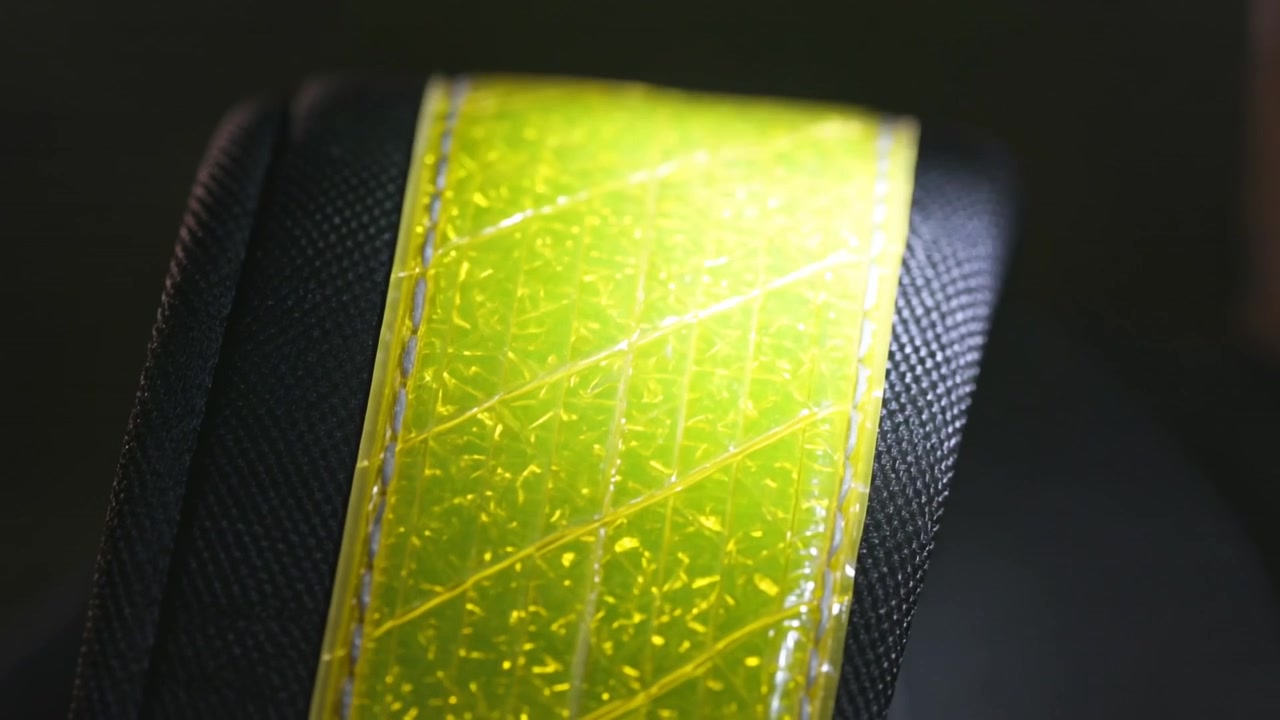 Shining light causing yellow tape brightening, centering on black strap for testing, showing flecks