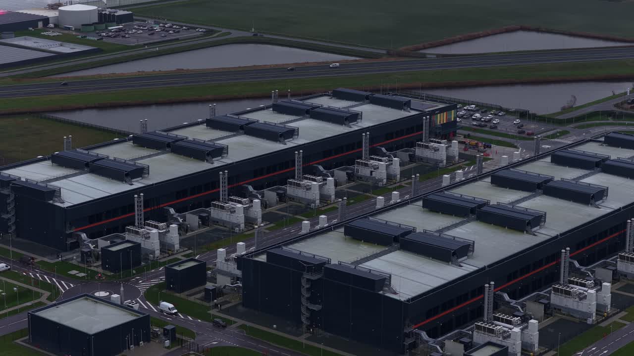 Aerial drone video of a large redundant colocation data center in Middenmeer, The Netherlands, showcasing massive data processing, storage capacity, and advanced AI computing infrastructure