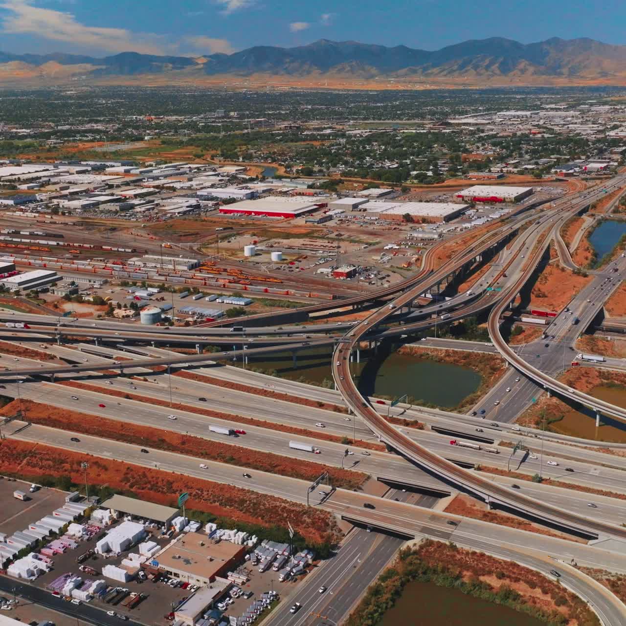 Motorways, loops and skyways of traffic system in Salt Lake City, Utah, United States. Sunny city view at backdrop of mountains
