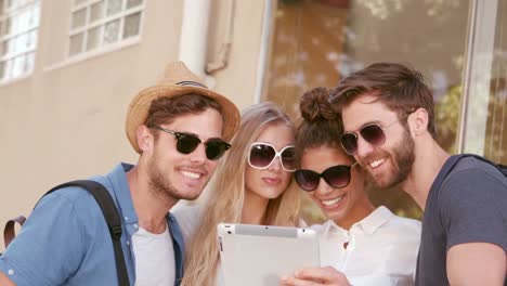 amigos hipsters sonrientes mirando la tableta
