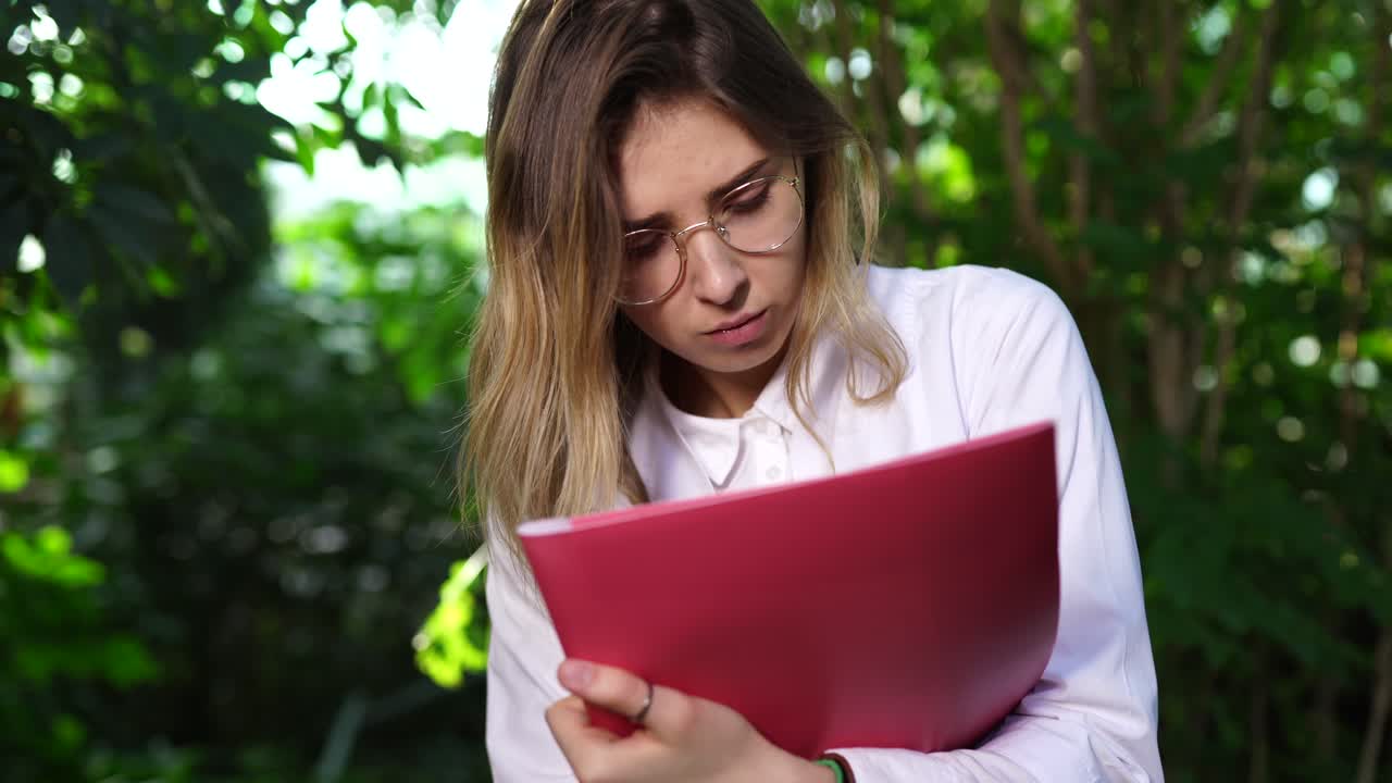 mujer leyendo documentos en un invernadero