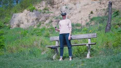 female in nature use goggles and rc motion control to take off fpv drone