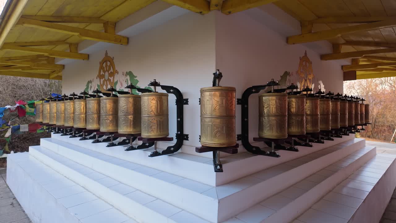 Traditional small Buddhist prayer wheels on the side of a Tibetan Buddhist stupa.