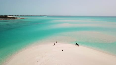 people on a white sandy beach in providenciales in the turks and caicos archipelago