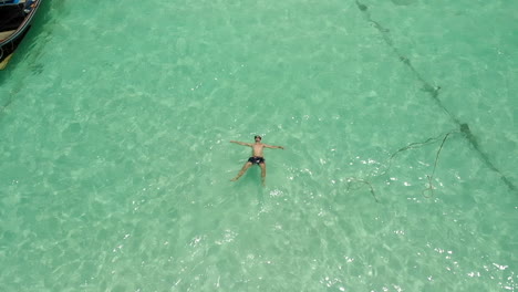 Hombre-Flotando-Y-Descansando-En-El-Agua-Clara-Del-Océano