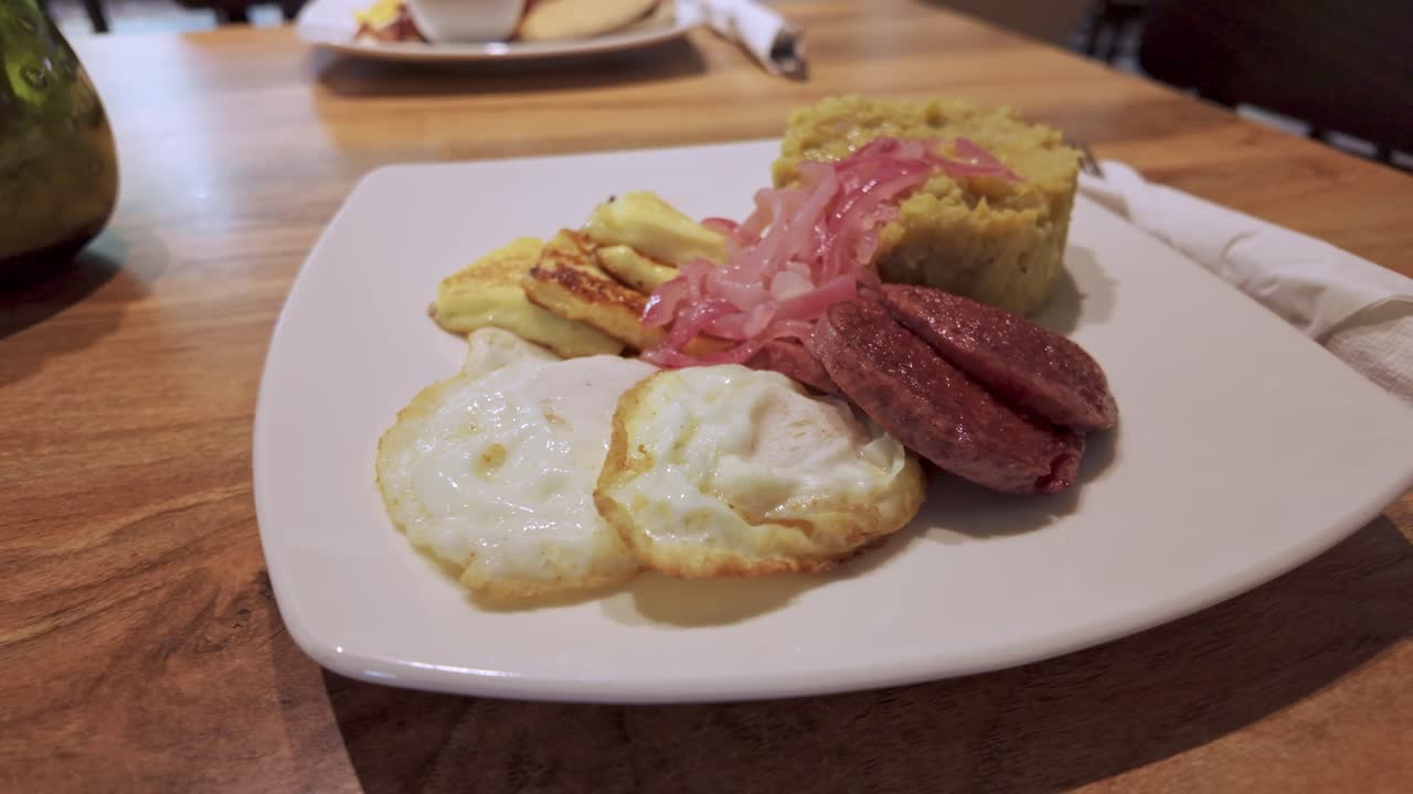 Typical Dominican breakfast, mashed of banana, eggs, fried cheese, salami, Los tre golpes. Close-up