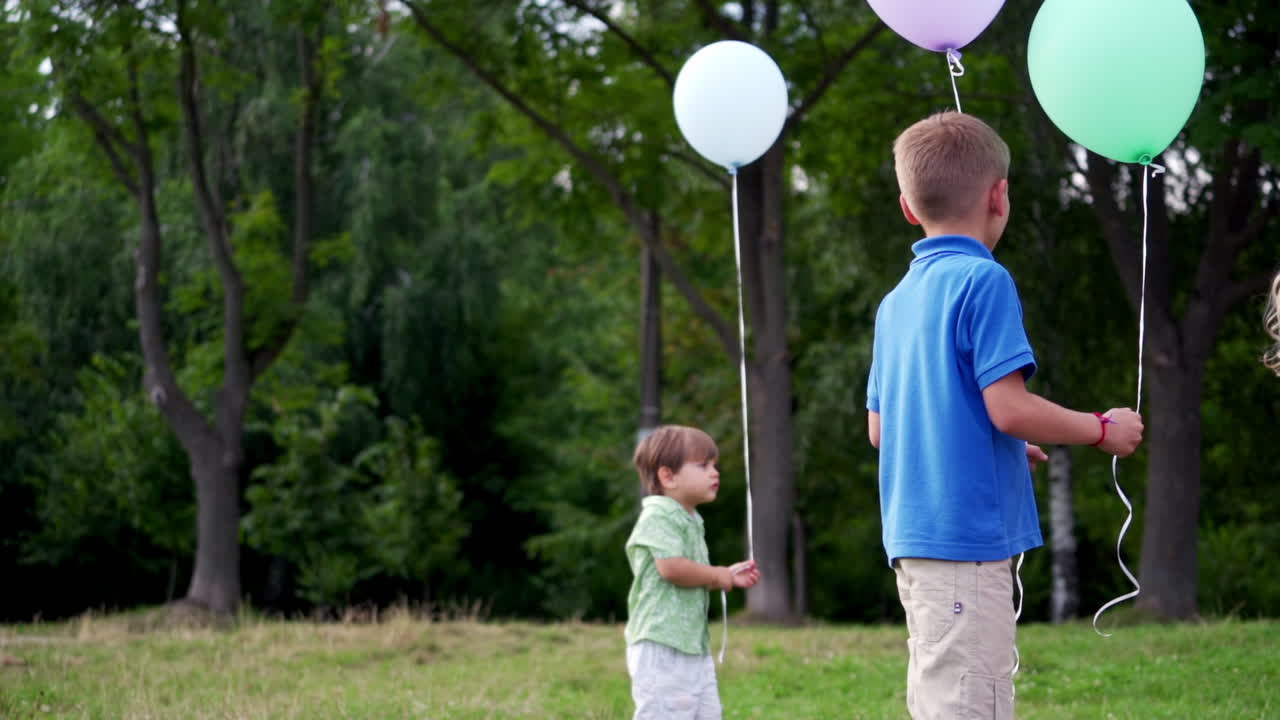 Children playing with baloons. Cute children celebrating birthday with baloons