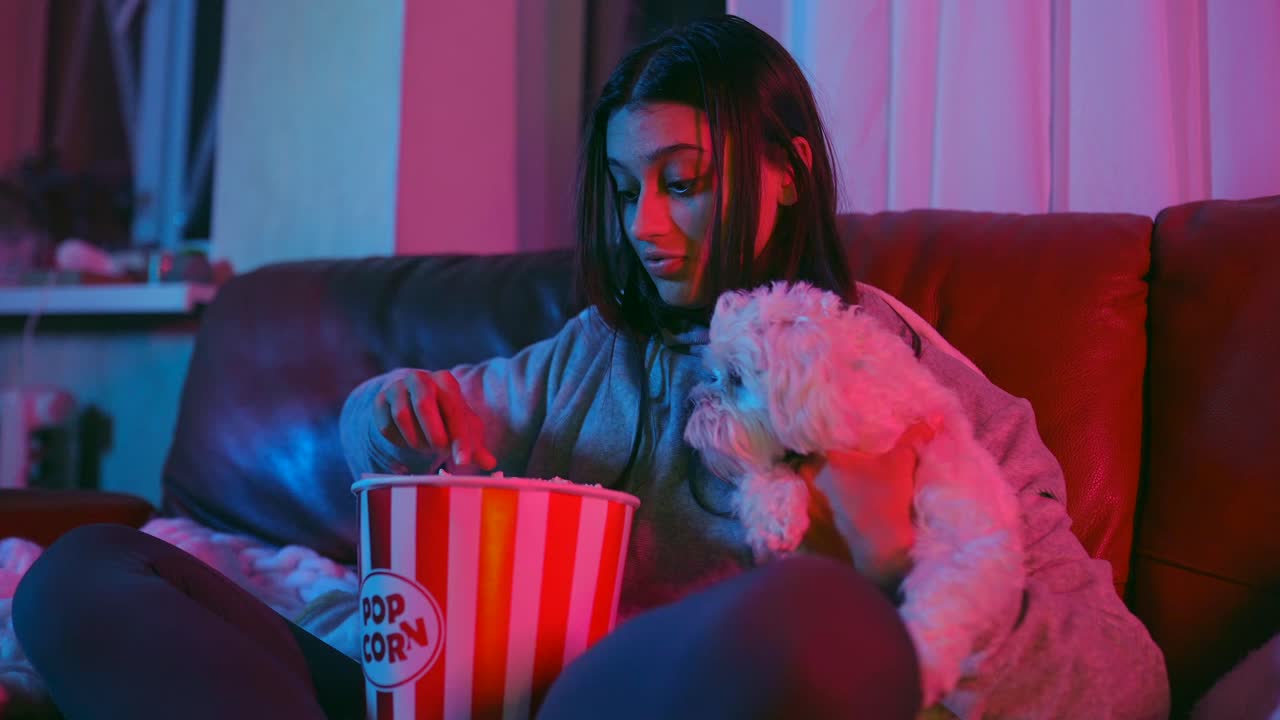 niña y su perro disfrutando de una noche de cine con palomitas de maíz