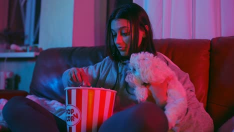 girl and her dog enjoying movie night with popcorn