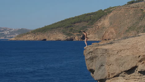 woman cliff diving into the ocean
