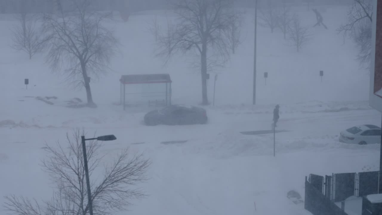 Person walking through heavy snowstorm blizzard during winter