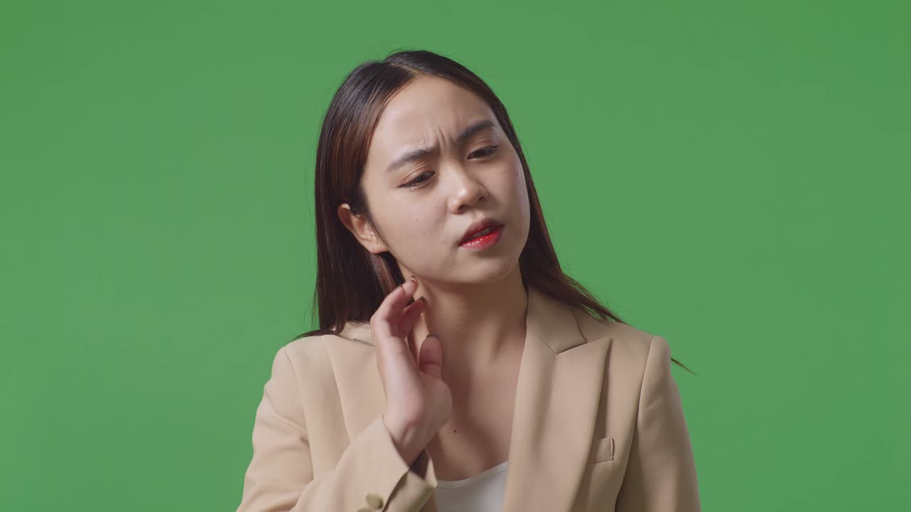 녹색 화면 앞에 서 있는 피곤 한 아시아 사업가 의 근접