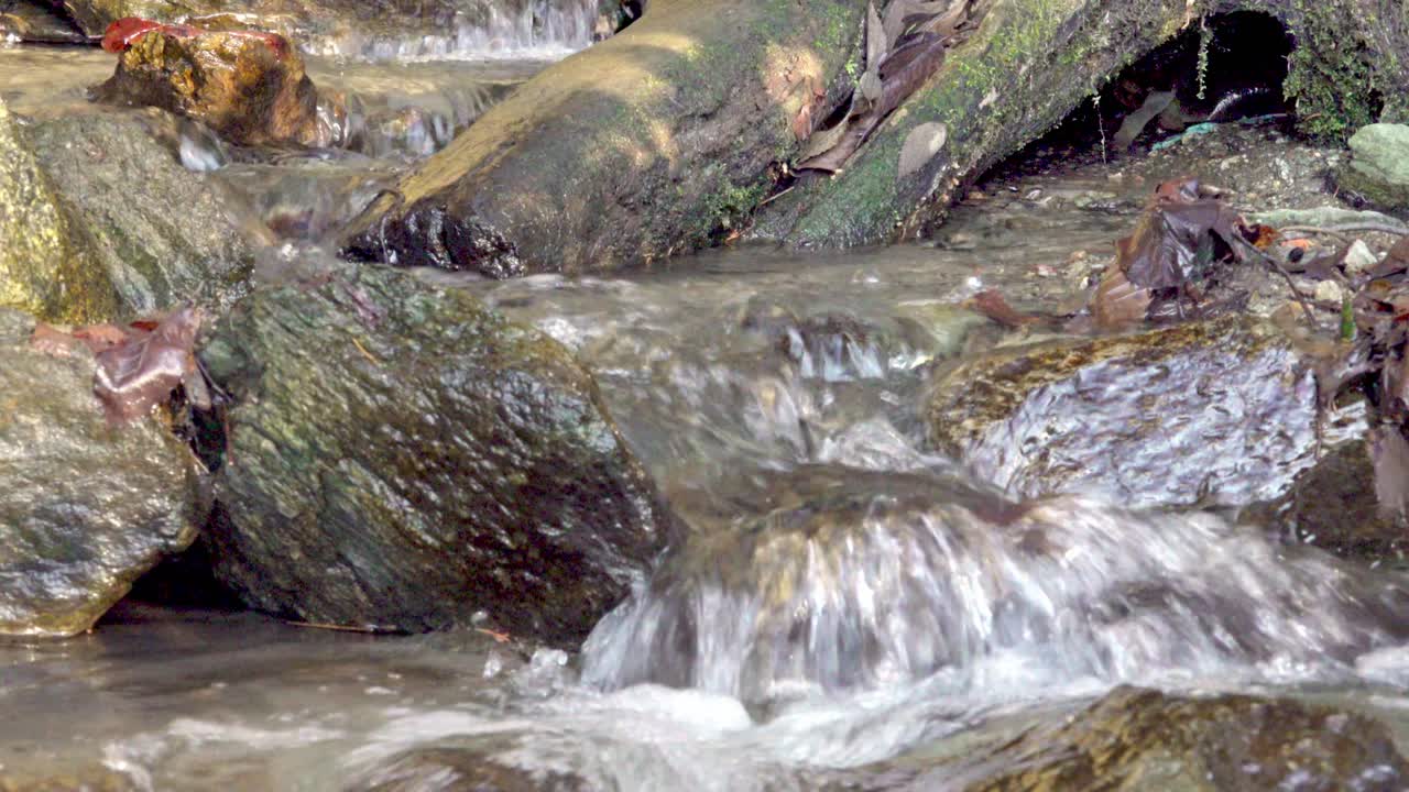Un ruscello naturale scorre su una superficie rocciosa.