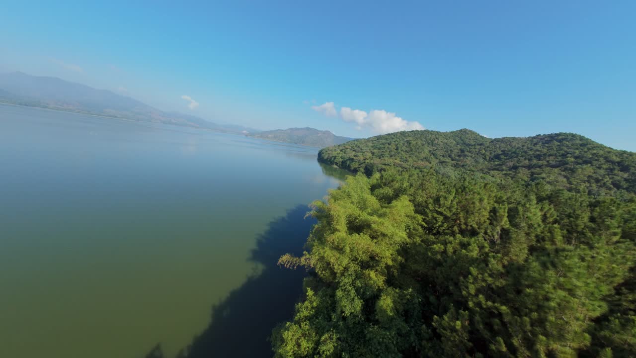 Fpv fought along coastline of Aniana Vargas national park in Dominican Republic. Green landscape scenery with trees and natural water of lakes.