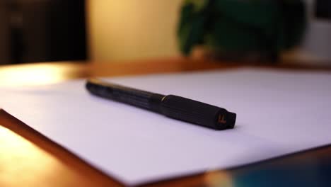 black permanent marker is placed on a piece of paper on a desk and taken away again