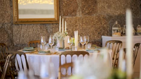 elegant wooden table setting with floral arrangements, fine plates, and cutlery – slow motion dining decor
