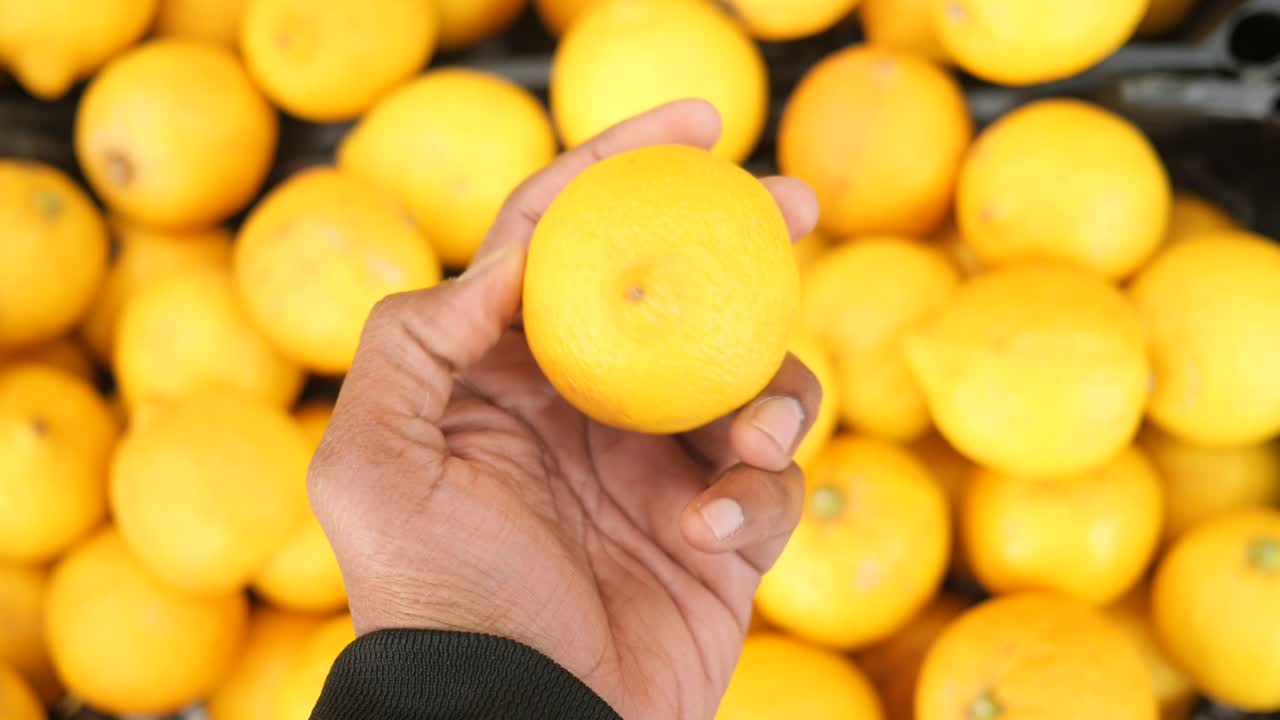 Hand holding a lemon in a market